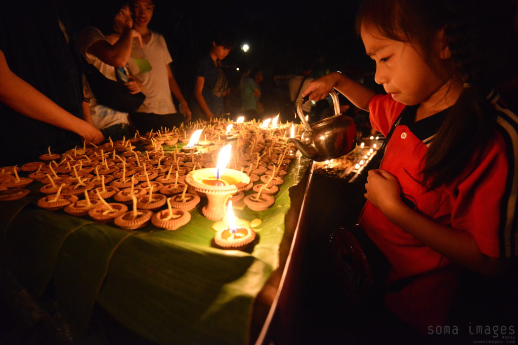 Young girl lighting candles Loy Krathong 2014